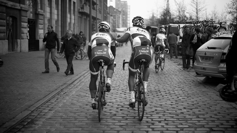 Andre Greipel chaperoned to the stage by a team-mate